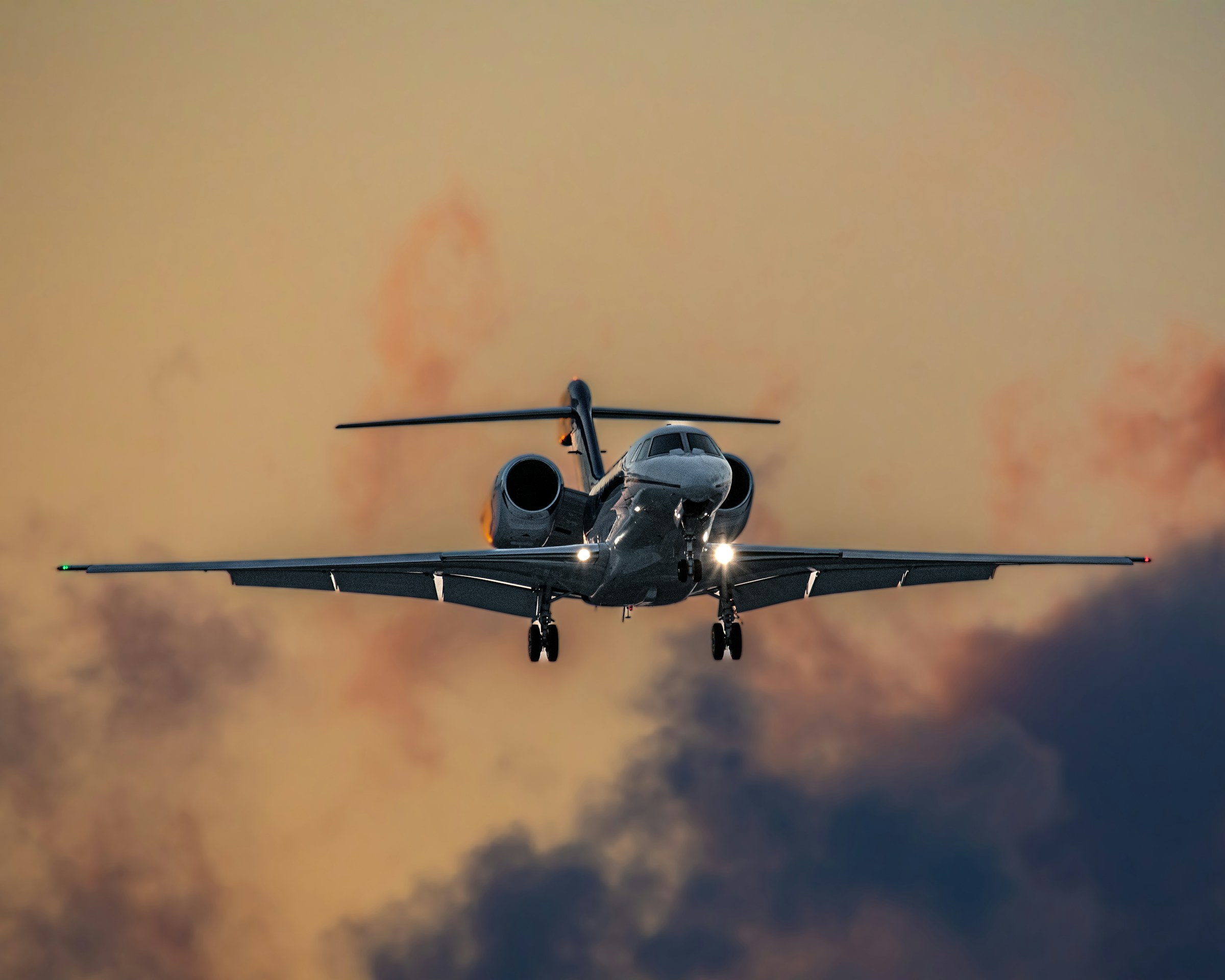 A private jet coming in to land under a soft evening sky